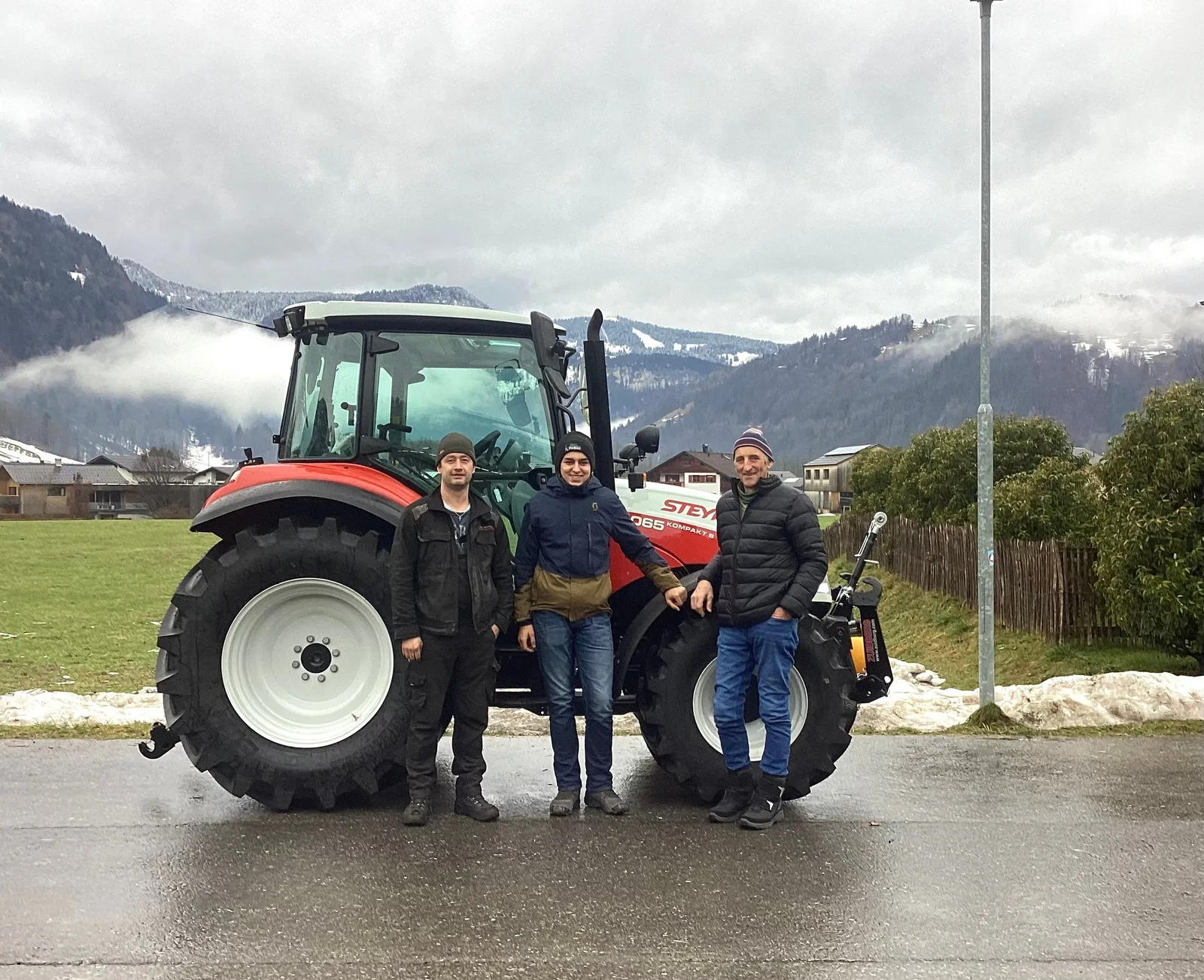 Steyr Kompakt 4065S bei Schneelage, drei Personen davor